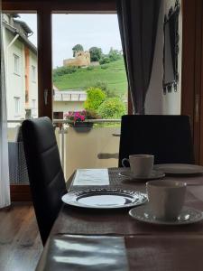 a table with two cups and a view of a castle at Apartment Rosalie Burgblick EuropaPark in ca 15min erreichbar in Kenzingen