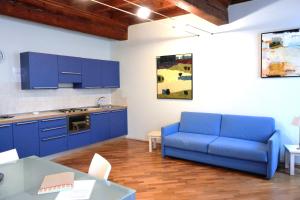 a living room with a blue couch and a kitchen at Residence Alcorso in Mantova