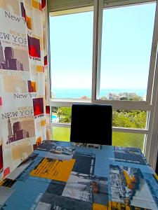 a desk with a laptop in a room with windows at Benalmádena Nice Sea Views ! in Benalmádena