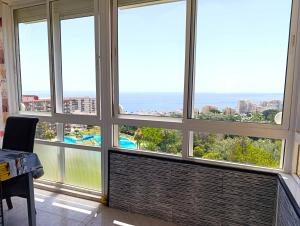 a room with large windows with a view of the ocean at Benalmádena Nice Sea Views ! in Benalmádena