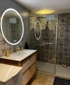 a bathroom with a sink and a shower with a mirror at Le Boudoir de Zine, une escapade au cœur des châteaux in Vallères