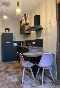 a kitchen with a table and two chairs at Le Boudoir de Zine, une escapade au cœur des châteaux in Vallères