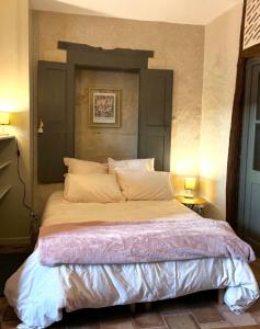 a large bed in a bedroom with two lamps at Le Boudoir de Zine, une escapade au cœur des châteaux in Vallères +6 photos