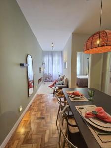 a kitchen and living room with a table and chairs at Seu Loft em BH, conforto e localização perfeita in Belo Horizonte