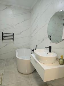 a white bathroom with a sink and a mirror at Stegor Suites in Maun +14 photos