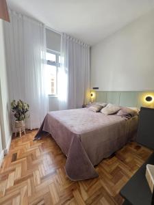 a bedroom with a large bed and a wooden floor at Seu Loft em BH, conforto e localização perfeita in Belo Horizonte +74 photos
