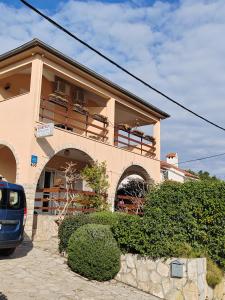 a building with a car parked in front of it at Apartman Ferri 3 in Vrbanj +5 photos