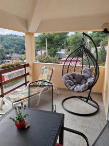 a porch with a swing and a chair on a balcony at Apartman Ferri 3 in Vrbanj