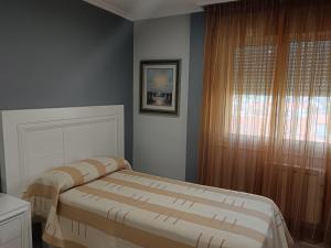a bedroom with a bed and a window at Apartamento Perla 2000 in Portonovo