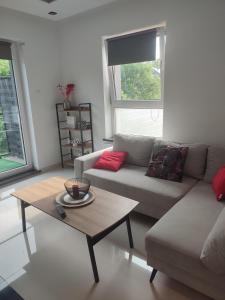 Una sala de estar con un sofá y una mesa de café. en 2 rooms near the main city, en Gdansk