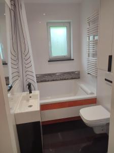 Un baño con bañera, inodoro y lavabo. en 2 rooms near the main city, en Gdansk