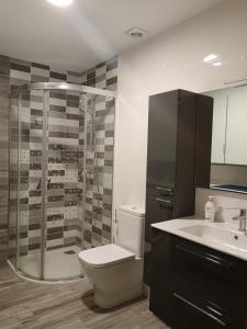 a bathroom with a shower and a toilet and a sink at Apartamento Perla 2000 in Portonovo +5 photos