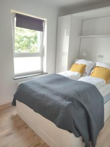 Un dormitorio con una cama grande y una ventana. en 2 rooms near the main city, en Gdansk