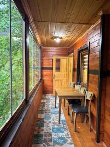 a dining room with a table and chairs and windows at Mavera Suite in Uzungöl