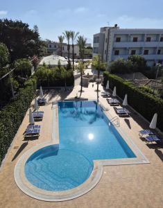 a swimming pool with lounge chairs and a building at Hotel Costa Azul in Balestrate