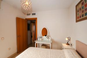 sypialnia z łóżkiem, stołem i lustrem w obiekcie Apartamento Deluxe: hidromasaje, terraza y vistas. w mieście Las Hortichuelas