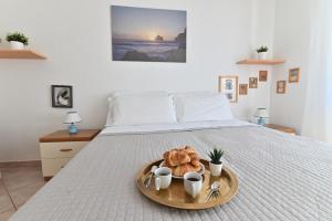 プーラにあるIzzHome BiHappyのベッドの上にトレイ(クロワッサン、カップ付)