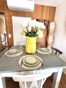 a table with plates and a vase with white flowers at FM Marina Vilamoura in Quarteira +7 photos