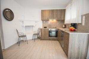 a kitchen with wooden cabinets and a table and chairs at Velanidia House in Lygia +17 photos