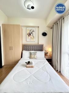 a large white bed with a tray on top of it at Modern Studio in Saint Dominique in Iloilo City