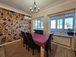 a dining room with a table and chairs and a stone wall at Loft Comfort House in Yerevan in Yerevan