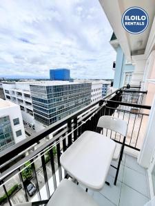 a balcony with two chairs and a view of a city at Modern Studio in Saint Dominique in Iloilo City