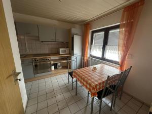 ノイヴィートにあるApartment in Neuwiedの小さなキッチン(テーブル、椅子付)、窓が備わります。