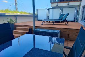 a deck with a chair and a bench on a balcony at Insider in Eckernförde