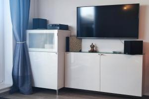 a white entertainment center with a flat screen tv on top at Insider in Eckernförde