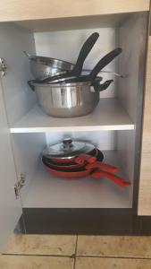 a shelf with a pot and a pan and scissors at Cerbere Terrimbo 2 in Cerbère