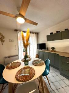 Una mesa de comedor con sillas y un ventilador de techo. en Appartement vue sur mer Le Grau du Roi, en Le Grau-du-Roi 6 fotos más