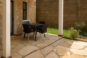 a patio with a black table and chairs on it at Peaceful Retreat for Drivers Near Arusha Park in Usa River