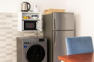 a kitchen with a refrigerator and a washing machine at Peaceful Retreat for Drivers Near Arusha Park in Usa River +6 photos