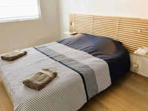 a bed with two towels on it in a room at Belle maison en bois Perros - La lande in Perros-Guirec