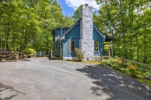 niebieski domek w lesie z podjazdem w obiekcie Cozy Timbers by Beyond Expectations w Hot Tub w mieście Rocky Grove