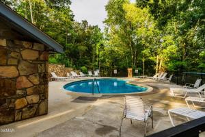 basen z krzesłami i kamienny budynek w obiekcie Cozy Timbers by Beyond Expectations w Hot Tub w mieście Rocky Grove