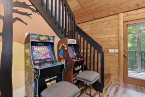 Pokój z automatem do gry w pinball i schodami w obiekcie Cozy Timbers by Beyond Expectations w Hot Tub w mieście Rocky Grove