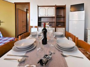 a table with plates and glasses and a bottle of wine at Pleasant seaside accommodation in Rosolina Mare in Rosolina Mare