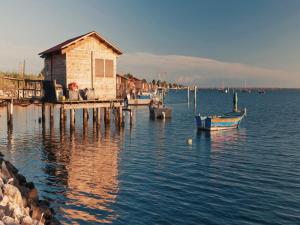 a building on a dock with boats in the water at Pleasant seaside accommodation in Rosolina Mare in Rosolina Mare