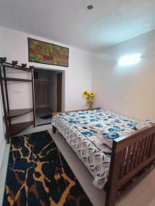 a bedroom with a bed and a rug at Reevilla in Madikeri