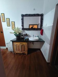 a bathroom with a sink and a mirror on the wall at Reevilla in Madikeri