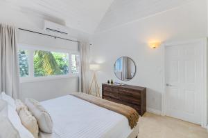 una camera bianca con letto e specchio di Cobalt Coast Resort a West Bay Altre 37 foto