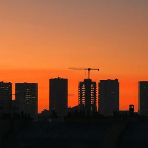 a city skyline at sunset with a crane at Vaugirard1 Appt Paris 15, Eiffel Tower View in Paris