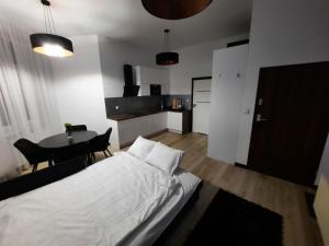 une chambre avec un lit blanc et une table dans l'établissement Apartament Jagiellońska, à Bydgoszcz