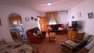 Una sala de estar con dos sofás y un televisor. en Sol Beach 24, en Playas de Orihuela