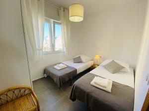 zwei Betten in einem Zimmer mit Fenster in der Unterkunft Murano by Alina365 in La Manga del Mar Menor