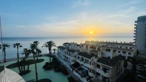 Blick auf ein Hotel und das Meer bei Sonnenuntergang in der Unterkunft Murano by Alina365 in La Manga del Mar Menor