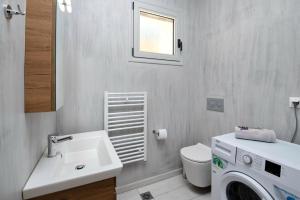 a bathroom with a sink and a washing machine in it at Tania Villas by PaxosRetreats in Gaios +34 photos