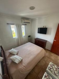 a bedroom with a bed with two pillows and a television at Depto Colon ER in Colón