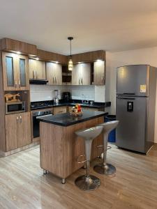 a kitchen with wooden cabinets and a stainless steel refrigerator at Departamento Medellín bello in Bello